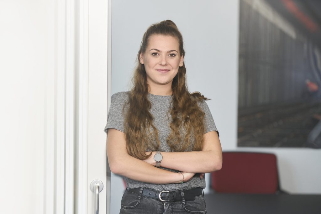 Junge Frau lehnt an Türrahmen